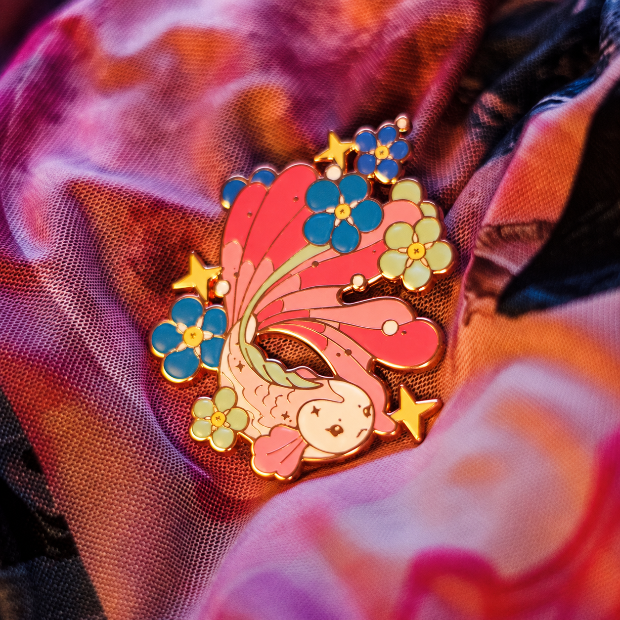 Pink fish enamel pin with colorful flowers; enhanced photograph of the finished product