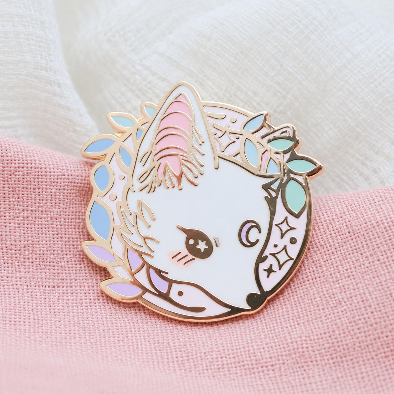 White fox enamel pin with pastel leaves and a moon; enhanced photograph of the finished product